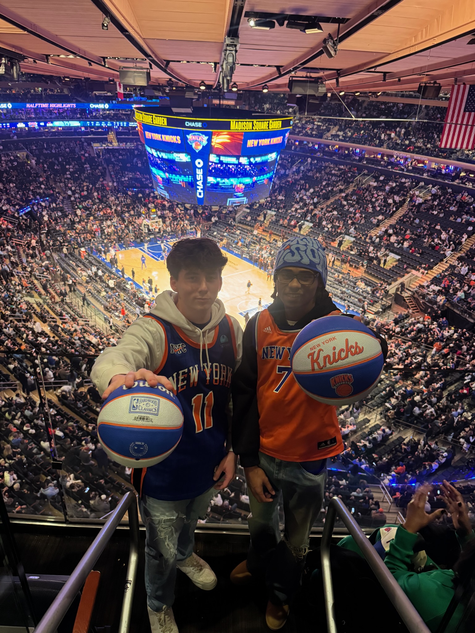 Two team members holding Knicks basketballs at Madison Square Garden